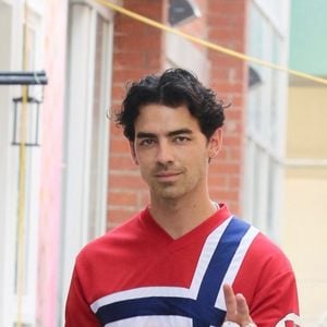 Joe Jonas fait le signe de paix et tout en rouge vêtu d'un maillot norvégien lors de ses déplacements dans le quartier de West Village à Manhattan.