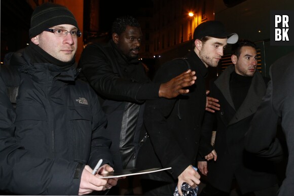 Robert Pattinson protégé par ses gardes du corps à Paris le 4 mars 2015