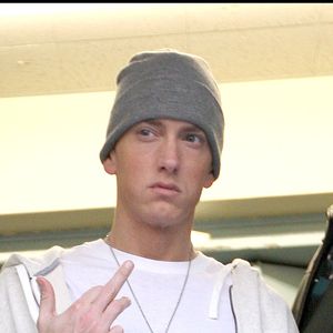 EMINEM FAIT UN DOIGT AUX PHOTOGRAPHES A SA SORTIE DES STUDIOS DE LA BBC A LONDRES.