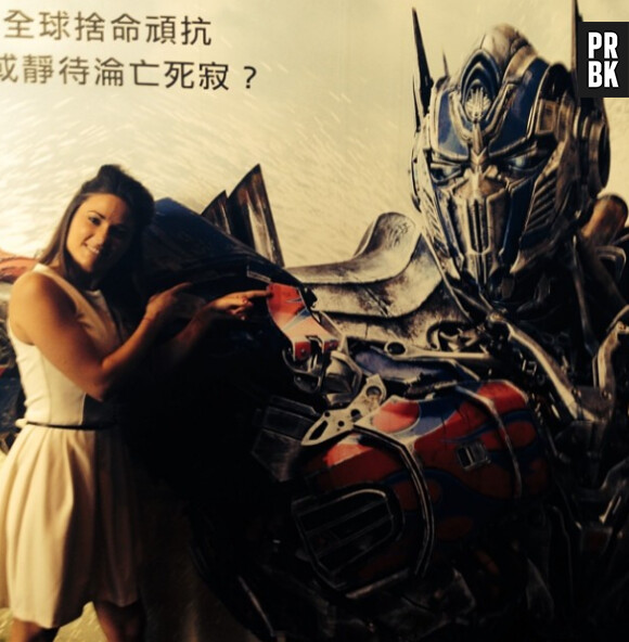 Capucine Anav devant l'affiche de Transformers 4, à Hong Kong