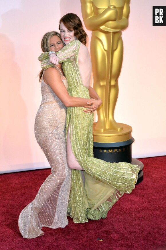 Jennifer Aniston câline Emma Stone sur le tapis rouge des Oscars, le 22 février 2015 à Los Angeles
