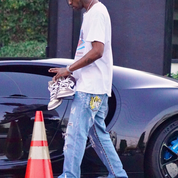 Exclusif - Travis Scott quitte ses bureaux au volant de sa nouvelle Bugatti Chiron Sports. D'une valeur de 5.5 milions de dollars, il en existe 30 exemplaires. Travis Scott est allé récupérer une paire de basket Nike qui n'est pas encore commercialisée. Los Angeles, le 21 juin 2022.


