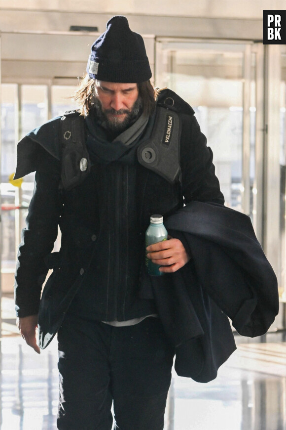 Keanu Reeves arrive à l'aéroport JFK de New York City, New York, Etats-Unis, le 30 décembre 2022. Keanu porte un bonnet noir assorti à son ensemble tout en noir et à des bottes. 