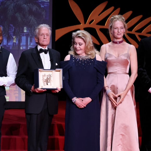 Pourtant, ca n'a pas forcément été simple de trouver celle qui restera pour l'éternité l'une des femmes fatales les plus iconiques du septième art. Notamment parce que Paul Verhoeven aimait à dire en guise de première approche à toutes celles qui candidataient "qu'il y aurait de la nudité, vraiment beaucoup de nudité dans ce film", relate Douglas, amusé.  
Michael Douglas reçoit la palme d'honneur, Catherine Deneuve, Uma Thurman - Cérémonie d'ouverture du 76ème Festival International du Film de Cannes, au Palais des Festivals à Cannes. Le 16 mai 2023. © Borde-Jacovides-Moreau / Bestimage  