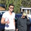 Liam Hemsworth salue les photographes pendant que Miley Cyrus se cache