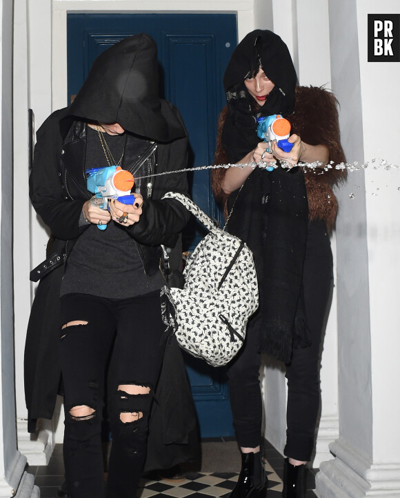 Cara Delevingne et sa petite-amie St Vincent arrosent les paparazzi, le 18 décembre 2015 à Londres