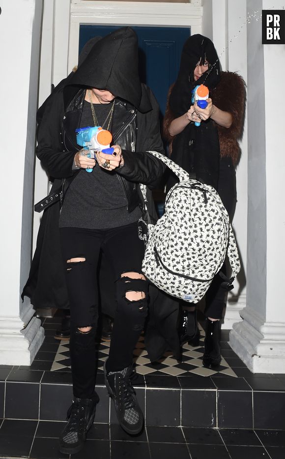 Cara Delevingne et sa petite-amie St Vincent arrosent les paparazzi, le 18 décembre 2015 à Londres
