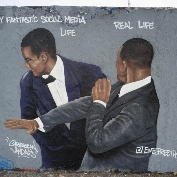 Graffiti de l'artiste Eme Freethinker du moment où WIll Smith a giflé le comédien Chris Rock lors de la 94ème cérémonie des Oscars en 2022 à Berlin, Allemagne, le 31 mars 2022. © Dan Herrick/Zuma Press/Bestimage  Germany, In Mauerpark Graffiti artist Eme Freethinker depicted the moment that WIll Smith slapped comedian Chris Rock at the 94th Academy Awards in 2022 after Rock made a joke about Smith's wife before presenting an award for best documentary film. The work was created on a remaining part of the former Berlin Wall that formed part of the death strip outside of former East Germany. 