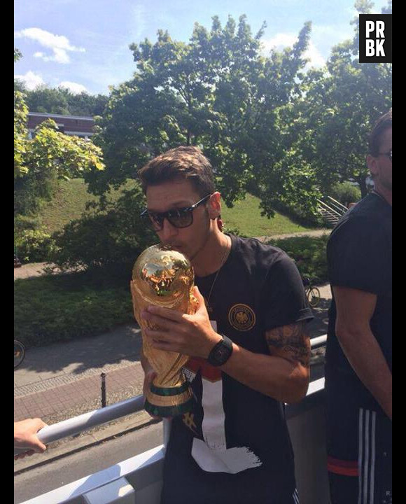 Mesut Özil embrasse la Coupe du Monde qu'il a remporté avec l'équipe allemande, le 6 juillet dernier