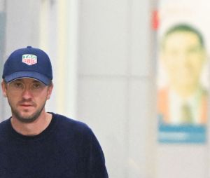 Exclusif - Tom Felton porte sa guitare en arrivant à l'aéroport JFK de New York City, New Yor, Etats-Unis, le 17 octobre 2022.  Exclusive - Harry Potter star Tom Felton seen carrying his guitar while walking with a woman thru JFK airport in New York City. The sighting comes after Felton revealed in a new memoir that he 'always had a secret love' for co-star Emma Watson. 