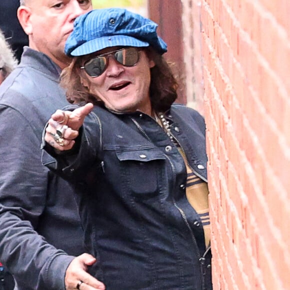 Exclusif - Johnny Depp, rasé de près, et ses musiciens arrivent à Kingston, le 13 octobre 2022. L'acteur-chanteur de 59 ans s'engouffre, entouré de ses gardes du corps, dans la salle de concert par l'entrée des artistes.  Exclusive - Johnny Depp arrives on tour bus to Kingston, New York. The 59 year old actor and musician showed off his new clean shaven look as he was ushered into the music venue by his bodyguards while holding a red plastic cup. October 14th, 2022. 