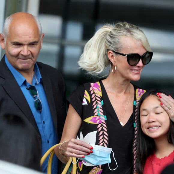 Semi-exclusif - Laeticia Hallyday et ses filles Jade et Joy arrivent, avec des masques de protection contre l'épidémie de coronavirus (Covid-19), à l'aéroport de Paris-Charles-de-Gaulle à Roissy-en-France, France, le 18 juin 2020.