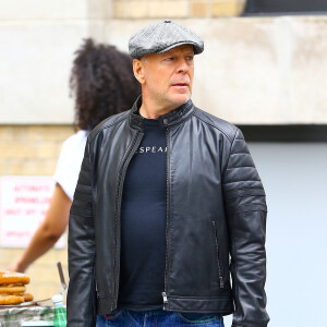 Bruce Willis se promène sur Prince Street à Soho, il porte une casquette grise et un parapluie rouge, New York, le 21 juin 2019.