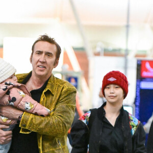 Nicolas cage porte sa fille August dans l'aéroport JFK à New York avec sa femme Riko Shibata le 25 mars 2023. Masquer le visage de l'enfant à la publication