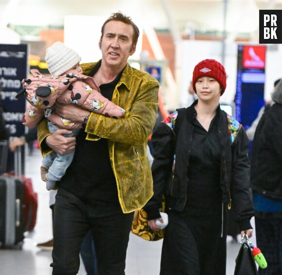 Nicolas cage porte sa fille August dans l'aéroport JFK à New York avec sa femme Riko Shibata le 25 mars 2023. Masquer le visage de l'enfant à la publication